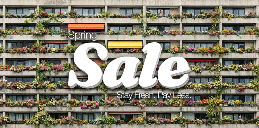 An urban building facade with abundant flowers on each balcony. Bold text reads "Spring Sale" with "Stay Fresh. Pay Less" below, conveying a vibrant, fresh tone.