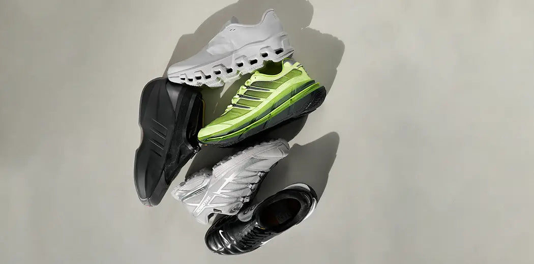 A dynamic arrangement of outdoor and performance sneakers on a light surface, featuring white, neon green, gray, and black shoes, each showcasing unique sporty designs.
