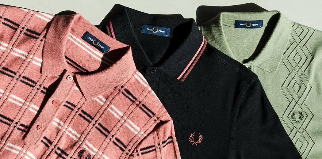 Three Fred Perry polo shirts are displayed: a pink checkered design, a solid black with red trim, and a green with diamond patterns, creating a stylish and casual vibe.