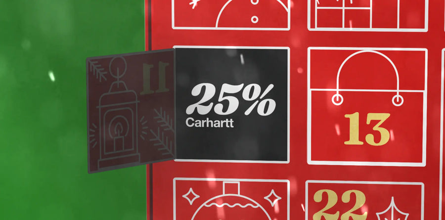 Folded casual Carhartt WIP clothing and accessories on a white surface, including a striped shirt, black cap, jeans with keychain, and a graphic tee. Stylish and laid-back vibe.