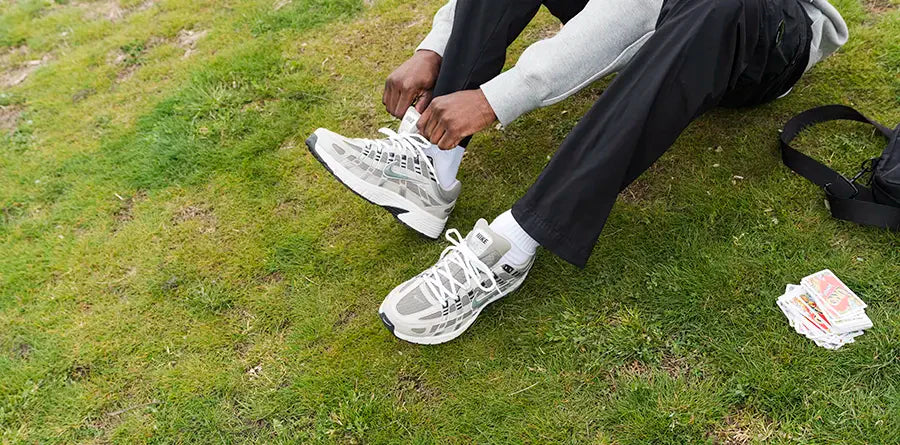 A stylish man rocking Nike P-6000 sneakers, black pants, and white socks. Fashion on point!