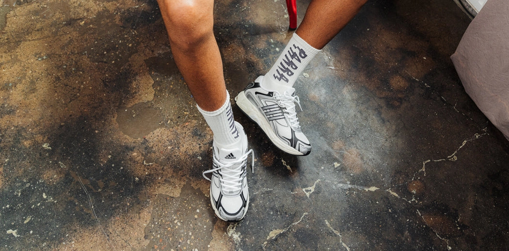 Adidas Response Classic running shoes resting on a couch.