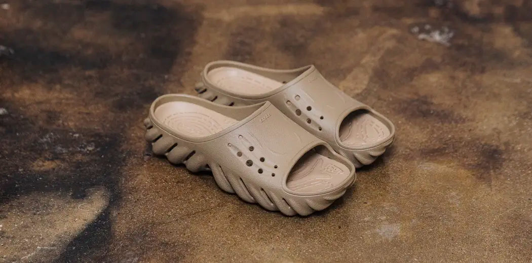 A pair of pink Crocs sandals with white straps and a textured sole, perfect for casual summer wear.