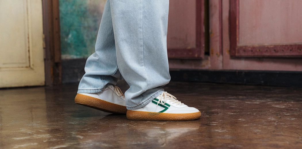 Men's vegan sneakers in white worn with jeans by a guy.