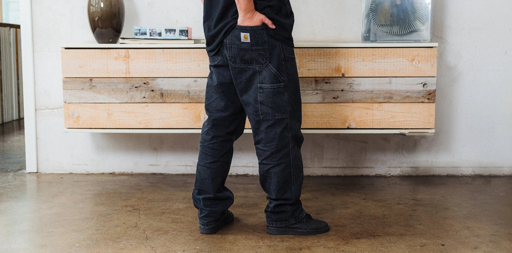 Male standing in room in jeans.