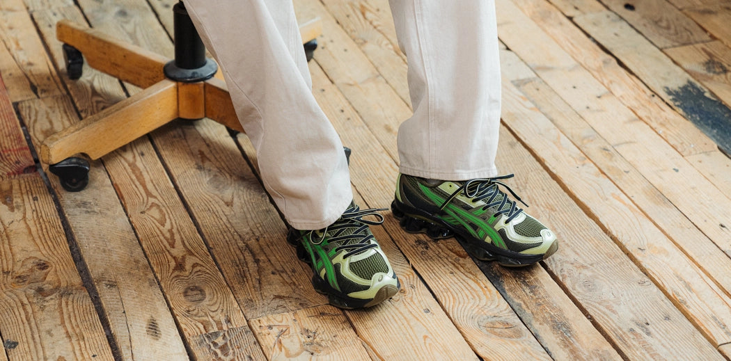 A pair of fashionable men's sneakers worn by a guy.