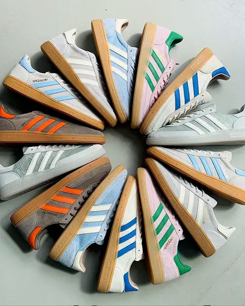 A circular arrangement of colorful Adidas Handball Spezial sneakers featuring various designs and vibrant color combinations on a gray background.